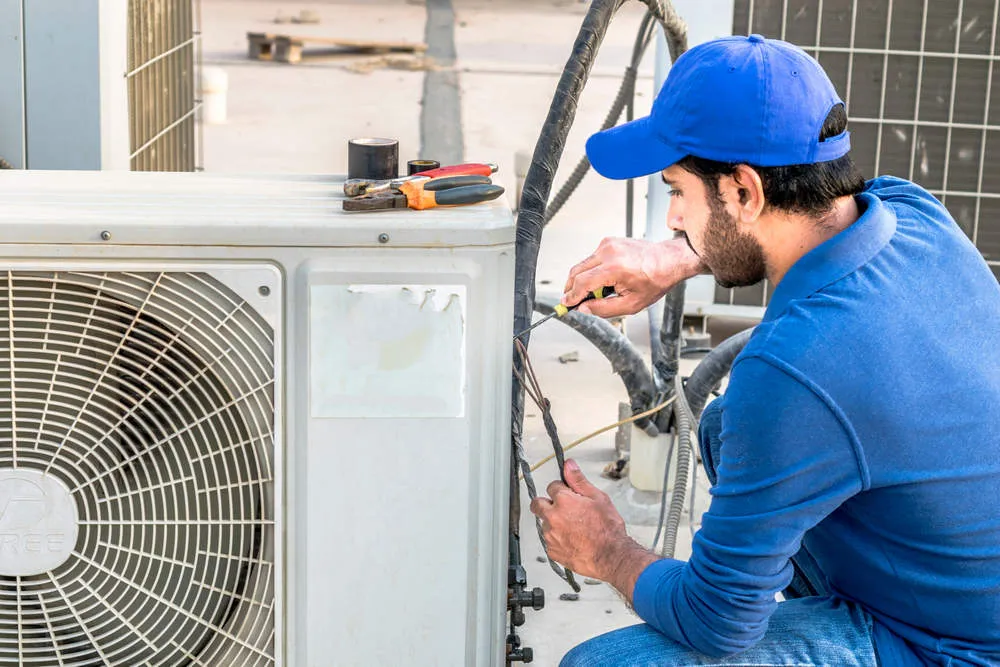 A repairman repairing a condenser
